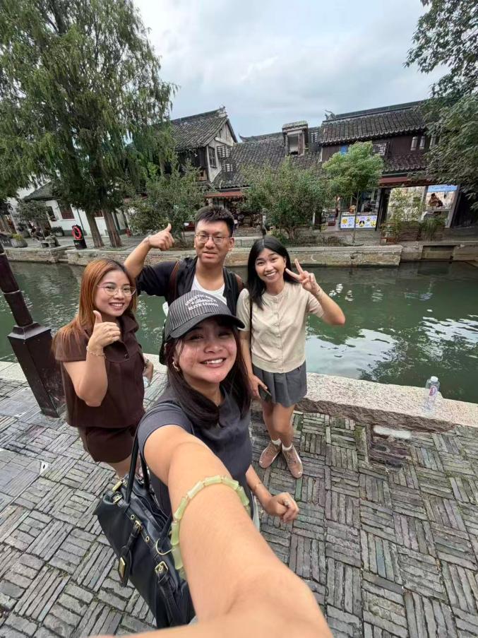 William Shan and three guests beside a canal in a historic water town